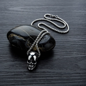 Gothic skull pendant necklace in silver stainless steel on black stone background