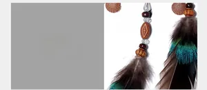 Detail of car dreamcatcher with gradient peacock feathers and brown wooden beads