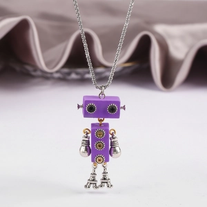 Detail of a purple robot pendant featuring movable limbs and gear accents on a velvet base