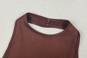 Gros plan des coutures d'une robe marron à col licou avec un tissu satiné