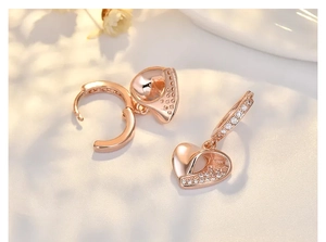 Detail of rose gold heart earrings featuring sparkling white zircon stone inlay