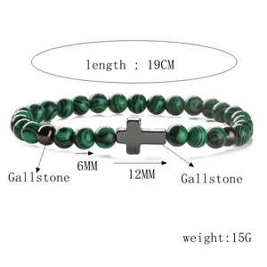 Bracelet élastique en perles de turquoise avec breloque croix sur fond blanc pur