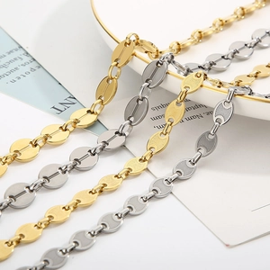 Minimalist 18k gold and silver coffee bean necklaces on a decorative ceramic plate