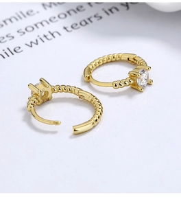 Detail showing 925 sterling silver stamp on golden rope hoop earrings with zircon stone