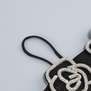 Close-up of silver rhinestone rose embellishment on a black strap fashion set