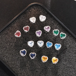 Macro shot of colorful heart-shaped crystal stud earrings set in a black jewelry box