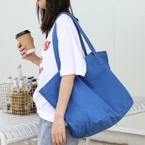 Minimalist blue canvas tote bag for women shown in a lifestyle casual outdoor setting