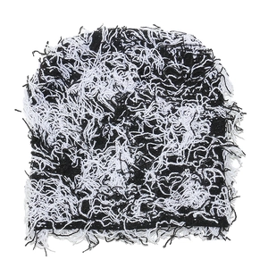 Close-up of distressed knit beanie with black and white contrast and frayed fringe details