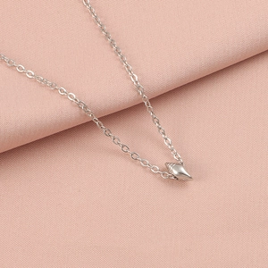 Detailed close-up of a silver starfish and seashell pendant on a delicate chain necklace