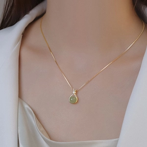 Elegant gold titanium necklace with round green jade pendant on a delicate snake chain