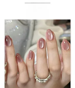 Detail of short rose gold cat-eye press on nails with shimmer effect on hand