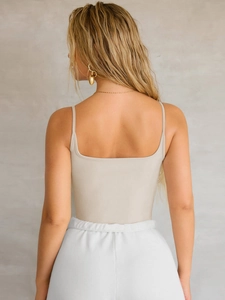 Detailed back view of a beige slim-fit spaghetti strap camisole top with open back