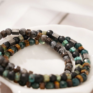 Handmade natural stone beaded bracelet with tiger eye and labradorite in a white bowl