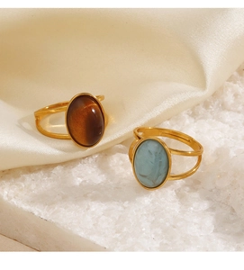 Close-up of vintage oval rings with brown cat-eye and blue marble stones in gold finish