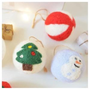 Close-up of wool felt Christmas ornaments with red stripes, snowmen and tree motifs