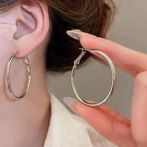 Detail of silver hoop earrings showing smooth polished surface and stylish circular design