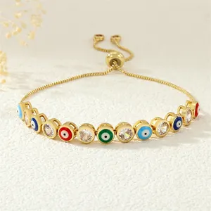 Macro view of adjustable snake chain bracelet with colorful enamel evil eye charms