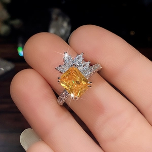 Macro shot of rectangular yellow zircon ring with intricate floral pavé diamond halo