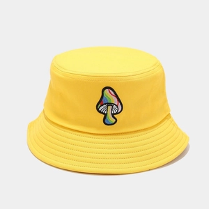 Close-up of rainbow mushroom embroidery on a bright yellow cotton bucket hat brim