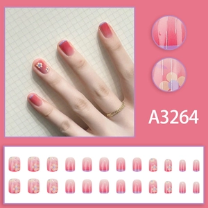 Pink gradient press-on nails with daisy floral art and French tips in a 24-piece set