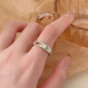 925 sterling silver ring with enamel rose and daisy flowers on a textured background