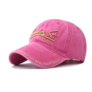 Detail of rose red washed cotton baseball cap with gold 3D embroidery and vintage texture