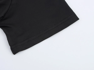 Close-up of double-needle stitching and fine fabric texture on black t-shirt sleeve