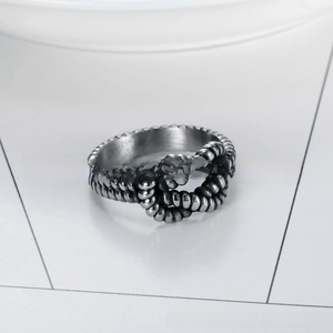 Detailed close-up of a silver twist knot stainless steel ring with industrial texture