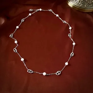 Elegant silver-plated necklace featuring white pearls and pig nose links on red silk