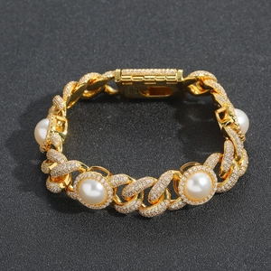 Macro shot of gold Cuban link bracelet with sparkling diamonds and white round pearls