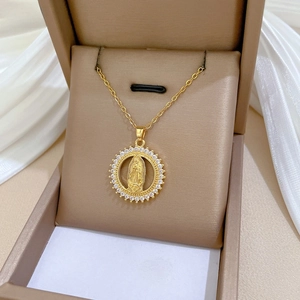 Close-up of gold Virgin Mary portrait pendant with sparkling crystal halo in a jewelry box