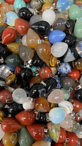 Close-up of polished teardrop crystal pendants showing diverse natural stone textures