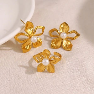 Golden flower jewelry set with white pearls including earrings and open ring