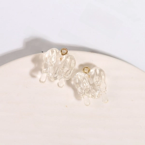 Macro shot of liquid heart-shaped resin pendants with gold rings for DIY jewelry
