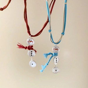Close-up of snowman pendants with colorful tassel scarves and velvet cord necklaces