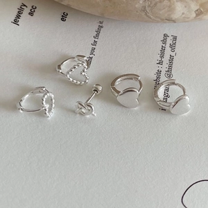 Detailed view of 925 sterling silver heart earrings and knot studs on white card