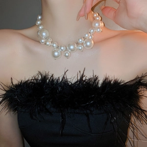 Close-up of Baroque pearl necklace with irregular white pearls on a model wearing black