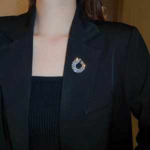 Detail of silver leaf brooch with sparkling cubic zirconia on a black blazer lapel