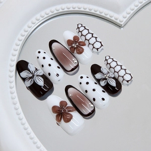 Vintage press-on nail set with 3D floral accents and polka dot patterns on a mirror base