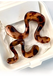 Detail view of tortoiseshell acetate claw clips in medium and small wavy designs