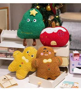 Close-up of plush Christmas pillows including a tree, gingerbread man, and cozy house