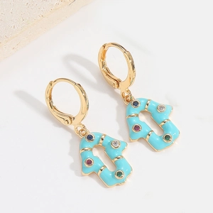 Close-up of golden arrow drop earrings with sky blue enamel and colorful zircons