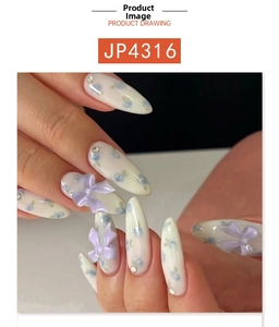 Detail of almond-shaped press-on nails with blue floral patterns and purple bow accents