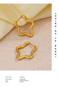 Détail de boucles d'oreilles étoile dorées 18K avec texture ondulée sur satin doux