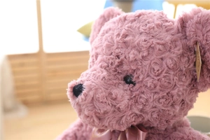 Close-up of pink rose swirl plush teddy bear with silk bow and detailed fur texture