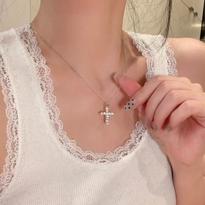 Macro shot of 925 silver cross necklace with moissanite pavé stones on model collarbone