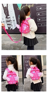 Pink toddler backpack with polka dot wings and safety leash for walking outdoors