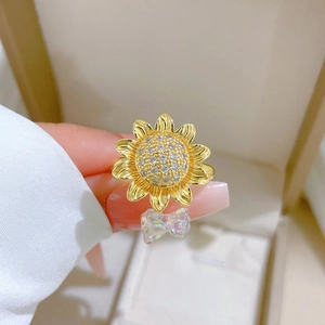 Detail of sunflower ring with crystal pave center and iridescent bow charm pendant