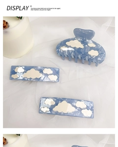Blue acetate hair claw and clips set with white clouds on a soft white tulle background