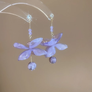 Macro shot of purple resin flower earrings with sparkling cubic zirconia detailing